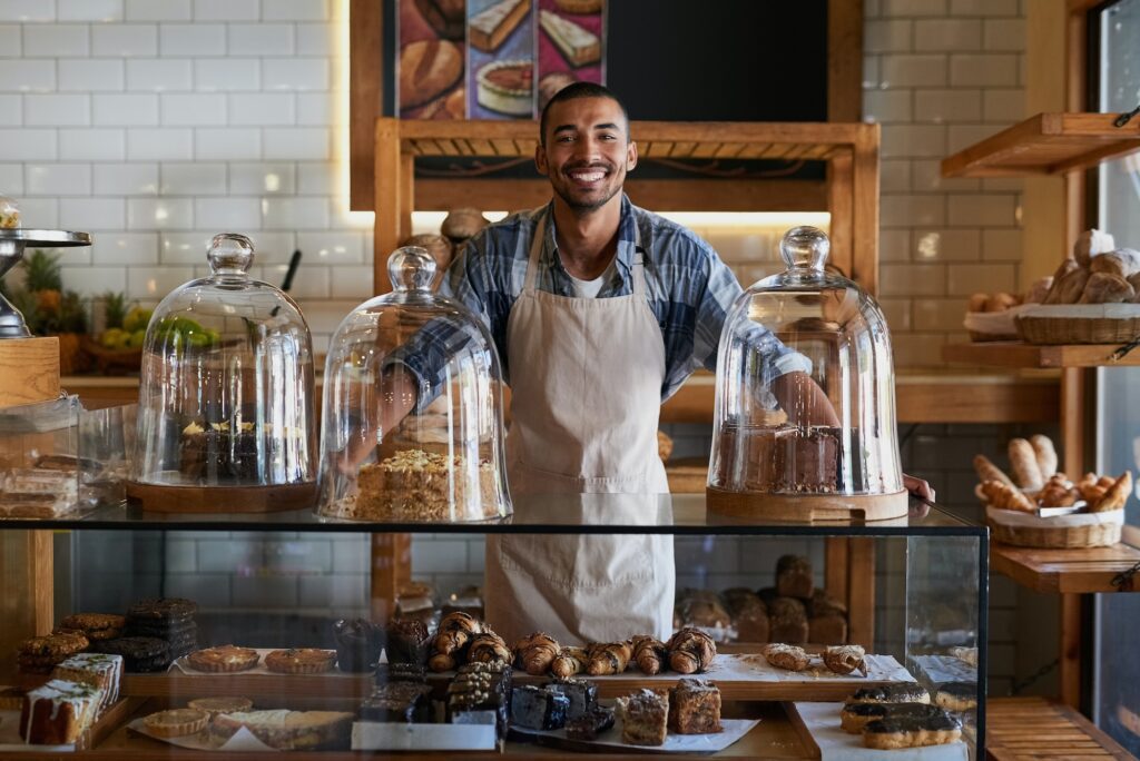 Portrait of a young business owner standing behind the counter of his bakery